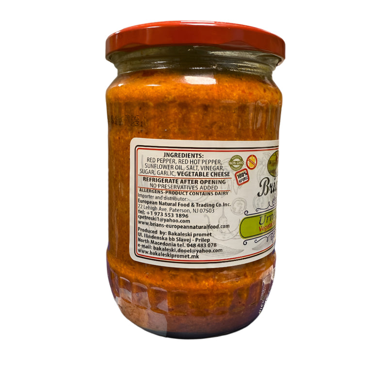 Jar of sauce with a label on a blue surface, with a tiled wall in the background.