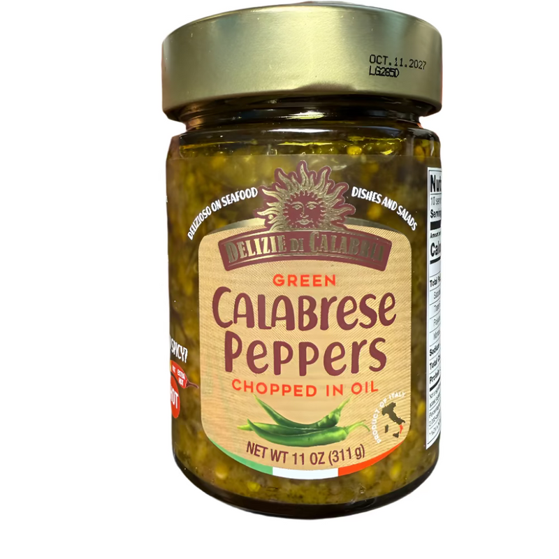 Jar of green calabrese peppers held by a hand on a dark surface