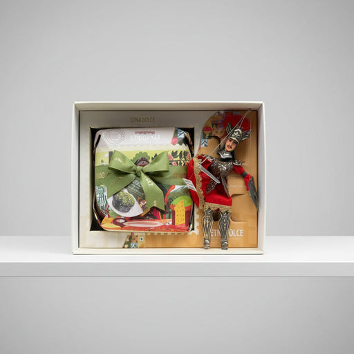Gift set with a nutcracker figure, wrapped items, and a spoon in a box on a gray background