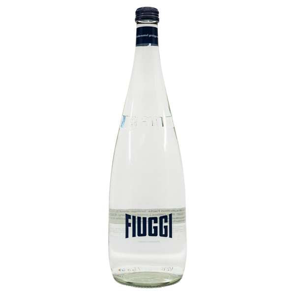 A clear glass bottle of Fluggi mineral water with a white label and dark blue branding, set against a plain white background.