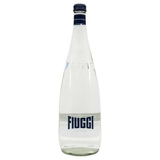 A clear glass bottle of Fluggi mineral water with a white label and dark blue branding, set against a plain white background.