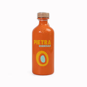 Orange bottle with 'Pietra Essenziale' branding on a white background
