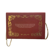 Decorative box with gold text and designs held in a hand, blurred store interior in the background