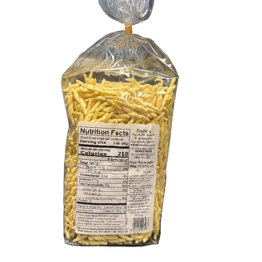 Packaged yellow noodles with a nutrition facts label on a desk.