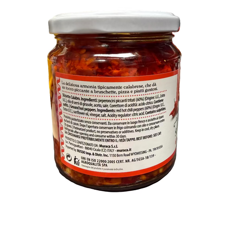 Jar of red pepper spread with a visible label on a kitchen counter.