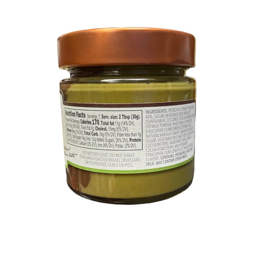 Jar of green spread on a counter with various items in the background