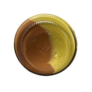 Close-up of a jar lid on a cluttered surface with various items in the background.