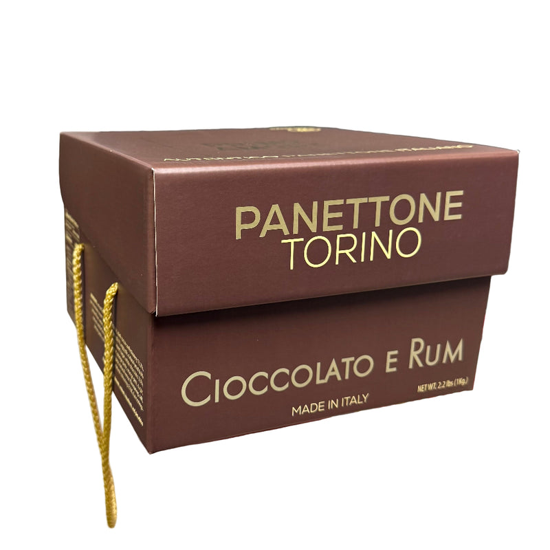 Hand holding a Panettone Torino Cioccolato e Rum box in a store setting
