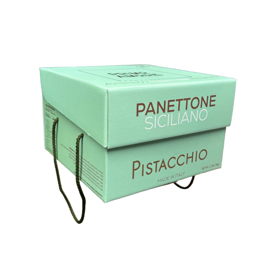 Hand holding a green box labeled 'Panettone Siciliano Pistacchio' in a store setting.