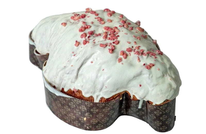 Baked good with white icing and red sprinkles on a marble surface